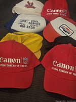 Overview of seven vintage hats in various colors and logos, showing brand and condition.