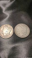 Obverse side of two Morgan Silver Dollars dated 1881 O and 1890 O showing Lady Liberty heads and dates.