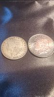 Obverse side of 1888 O and 1896 Morgan silver dollars showing Lady Liberty profile.