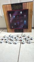 Photo showing new Swift Cup display case box with mini NFL mugs arranged in front on a tiled floor.
