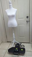 Full view of white female mannequin on stand with Steamfast steam press on floor underneath