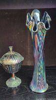 Photo showing the iridescent blue carnival glass vase and matching candy dish side by side on a dark surface