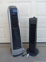 Photo of two space heaters, a tall silver and black Lasko heater and a smaller black heater standing side by side.