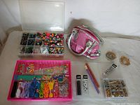 Full overview of the craft lot showing various bead organizers, crafting threads, metal rings, and a pink handbag