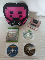 Nintendo DS console, Xbox and Wii game discs, pixelated gaming-themed bag