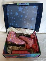 Pair of pink holographic women's roller skates in original box with pink wheels