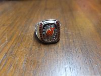 Front view of the ring showing New Jersey Devils logo surrounded by clear stones.