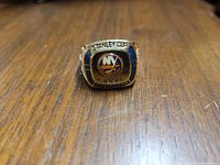 Front view of the gold-tone men's New York Islanders 1980 Stanley Cup championship ring, showing logo and inscriptions.
