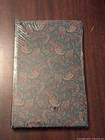 Front view of the paisley journal in original shrink wrap, showing detailed pattern and condition