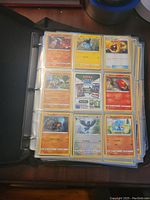 Binder open showing plastic sleeves with Pokemon TCG cards including multiple cards such as Combee, Wurmple, and others in very good condition