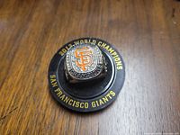 Top view of the ring showing the orange SF logo with surrounding clear rhinestones and the text '2012 WORLD CHAMPIONS SAN FRANCISCO GIANTS' on the base mount.