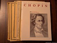 Six Chopin piano music books stacked on table, showing front covers and sides with classical-style borders.