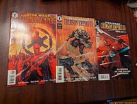 Three Star Wars Crimson Empire comic books laid out on wooden surface, showing front covers with colorful artwork and titles.