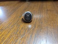 Front view of men's ring showing black face with silver engraved crowned TSM emblem