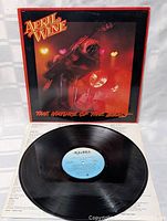 Black vinyl record with blue Aquarius label detail, partially on top of the inner sleeve and cover.