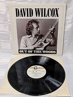 Front cover of David Wilcox Out Of The Woods album showing black and white photo of artist playing guitar.