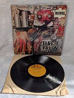 Front of album cover with colorful robot art and vinyl record partially visible inside plain paper sleeve