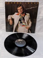 Front cover image of George Jones' 'I Am What I Am' LP showing George Jones in cream suit and colorful shirt.