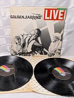 Photo of the two black vinyl records laid out, showing MCA Records labels and original album sleeve with band performing on front.