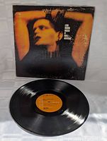 Photo showing vinyl LP and original album cover with wear and scuff marks