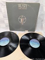 Front view of Rush Archives album cover and two vinyl records laid out
