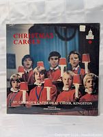 Front cover of the sealed St. George's Cathedral Choir Christmas Carols vinyl LP, featuring choir boys in red robes holding candles.
