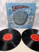 Front cover of the Super Rock Double LP with track listing featuring 20 artists and a Superman-style logo.