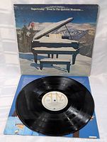 Vinyl LP record laid out next to open album sleeve showing label and vinyl condition.