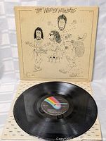 Vinyl record and album cover with caricature illustration of the band members on the front.