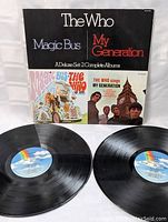 Front cover of double album set showing 'The Who Magic Bus My Generation A Deluxe Set: 2 Complete Albums' with vinyl records displayed.
