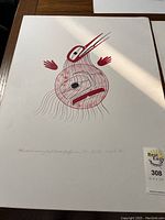 Photo showing full first artwork featuring stylized hummingbird with minimalistic red and black lines and shapes on white background, signed and titled below.