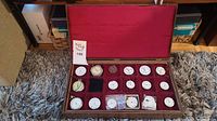 Overview of wooden pocket watch case with velvet lining and assorted watch cases, dials and parts