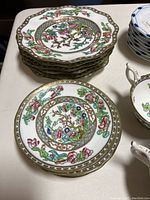 Coalport dessert plates with detailed floral patterns and gold trim stacked on table