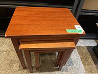 Three wooden nesting tables nested together showing relative sizes and overall design
