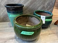 Photo shows all three ceramic plant pots placed together, visible measurements on green labels, varied green shades and blue accents.