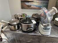Full view of the set including pots, slow cooker, stand mixer, and accessories on table.