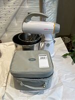 Sunbeam Mixmaster stand mixer with two bowls and Oster hand mixer carry bag in front