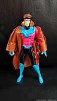 Front view of 1992 X-Men Gambit action figure wearing removable brown trench coat with bright pink chest armor, blue gloves and boots, and black pants.