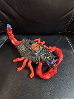 Scorpion-shaped playset closed, showing black body with red claws and tail
