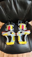 Pair of laser tag guns and wearable vests on a black chair
