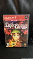 Front cover of the Dark Cloud PlayStation 2 Greatest Hits game showing character artwork and branding.