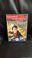 Front cover of the PlayStation 2 game case showing Harry Potter artwork labeled 'Greatest Hits'.