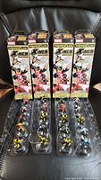 Overview of 20 X-Men HeroClix figures in original packaging boxes, showing four boxes on a chair.