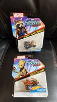 Photo of two sealed Hot Wheels cars, Rocket Raccoon and Groot Gokart, from Marvel Guardians of the Galaxy Vol. 2 in original packaging.