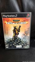 Front cover of Warhammer 40000 Fire Warrior PlayStation 2 game case showing main artwork and branding.
