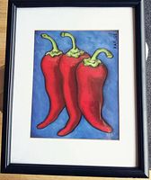Full view of the framed art print depicting three red chili peppers with green stems on a blue background, signed by Rafuse
