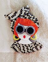 Close-up front view of the colorful art pin showing the face with sunglasses, red hair, headscarf, and earrings.