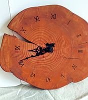 Front view of the round redwood slice clock showing tree rings, Roman numeral hour markings and black clock hands
