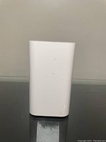 Front view of Apple AirPort device, showing smooth white vertical body