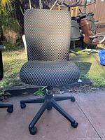 Front view of an office chair with multicolor checkered fabric upholstery showing seat and backrest condition